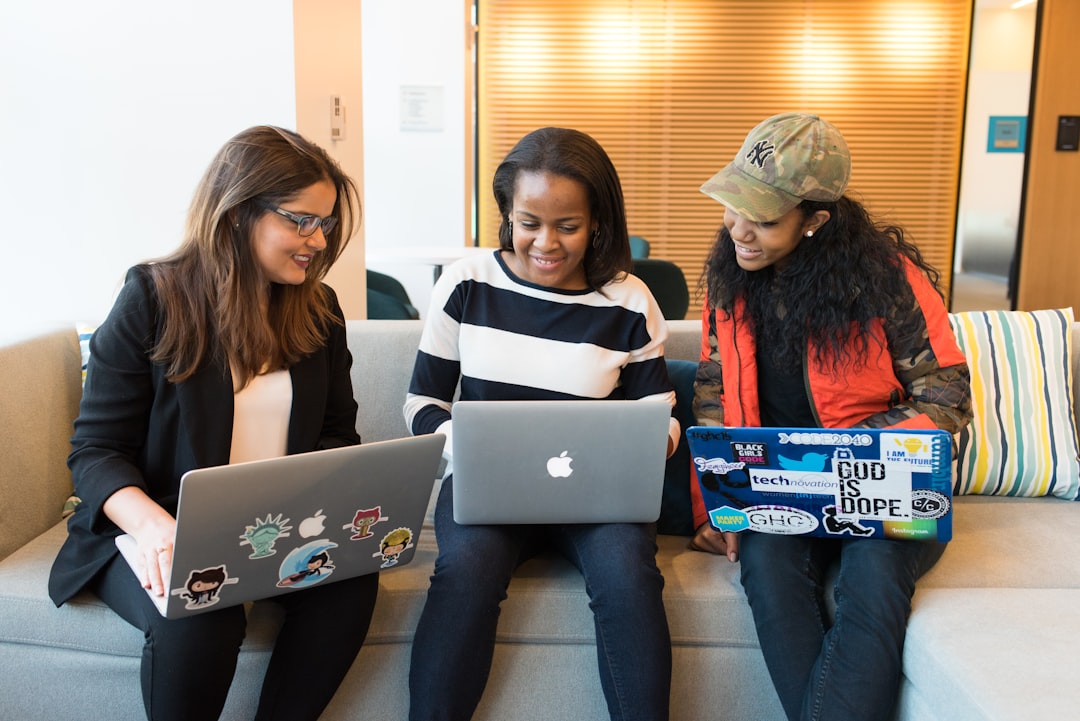 three women sitting on sofa with MacBook diversity, inclusion, teamwork