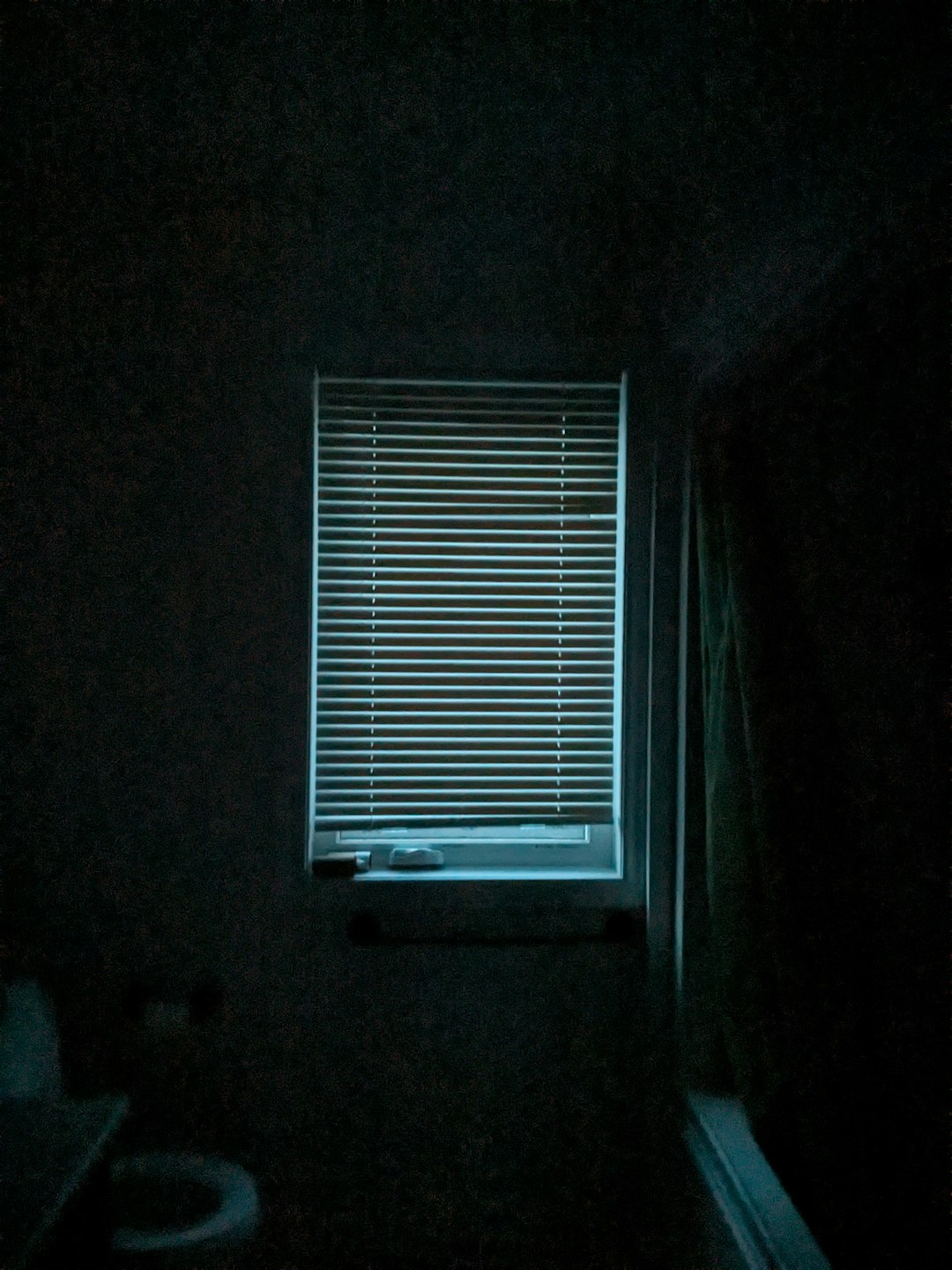 a dark bathroom with a window and a toilet windows computer sleep hibernate