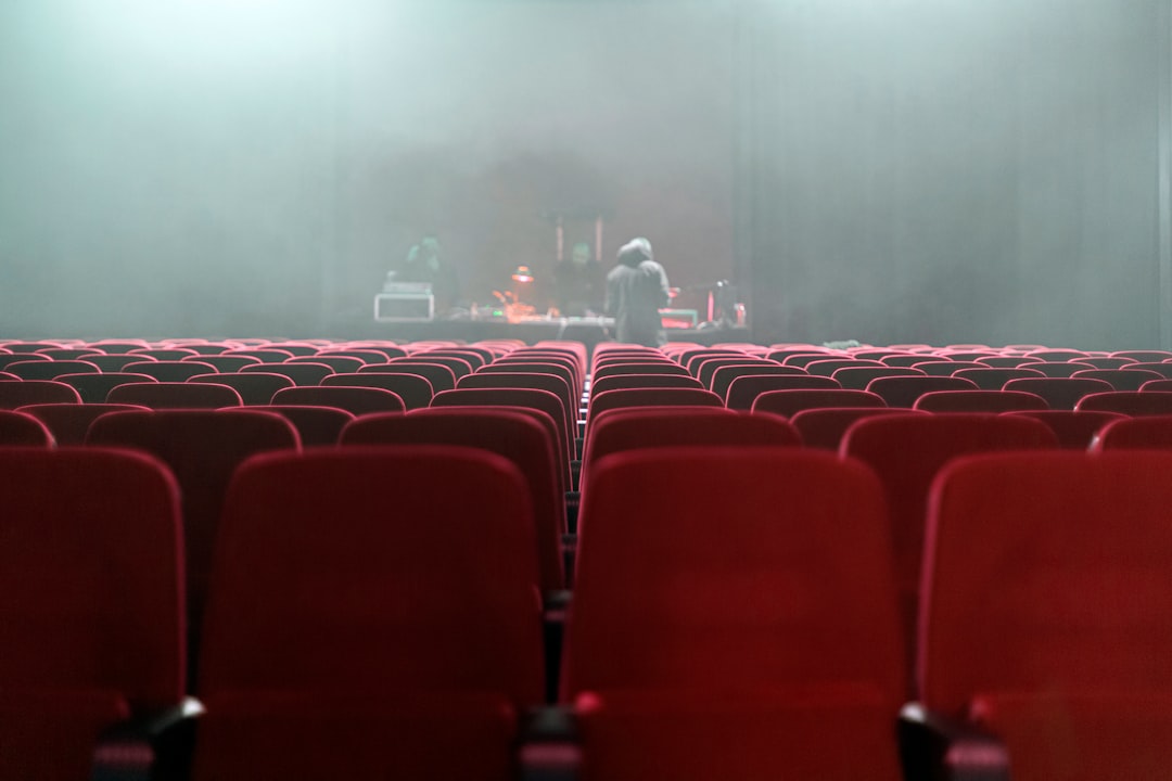 people sitting on red chairs watching a band performing on stage ticket purchase error, concert purchase fail, frustrated user