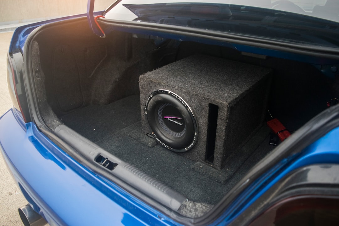 A car trunk contains a subwoofer system. bose speaker, outdoor dj, battery powered
