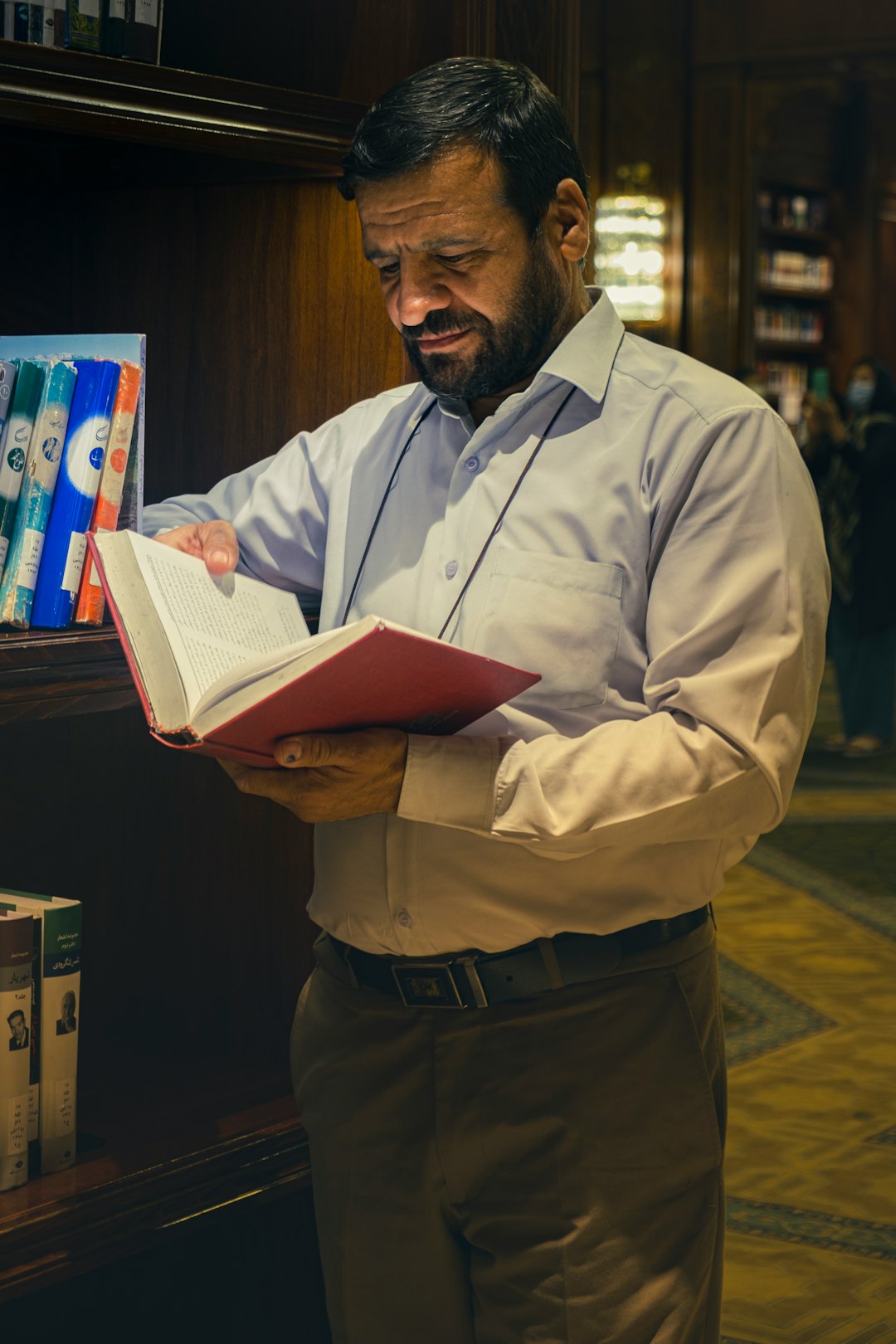 a man reading a book in a library author profile, biography, expert