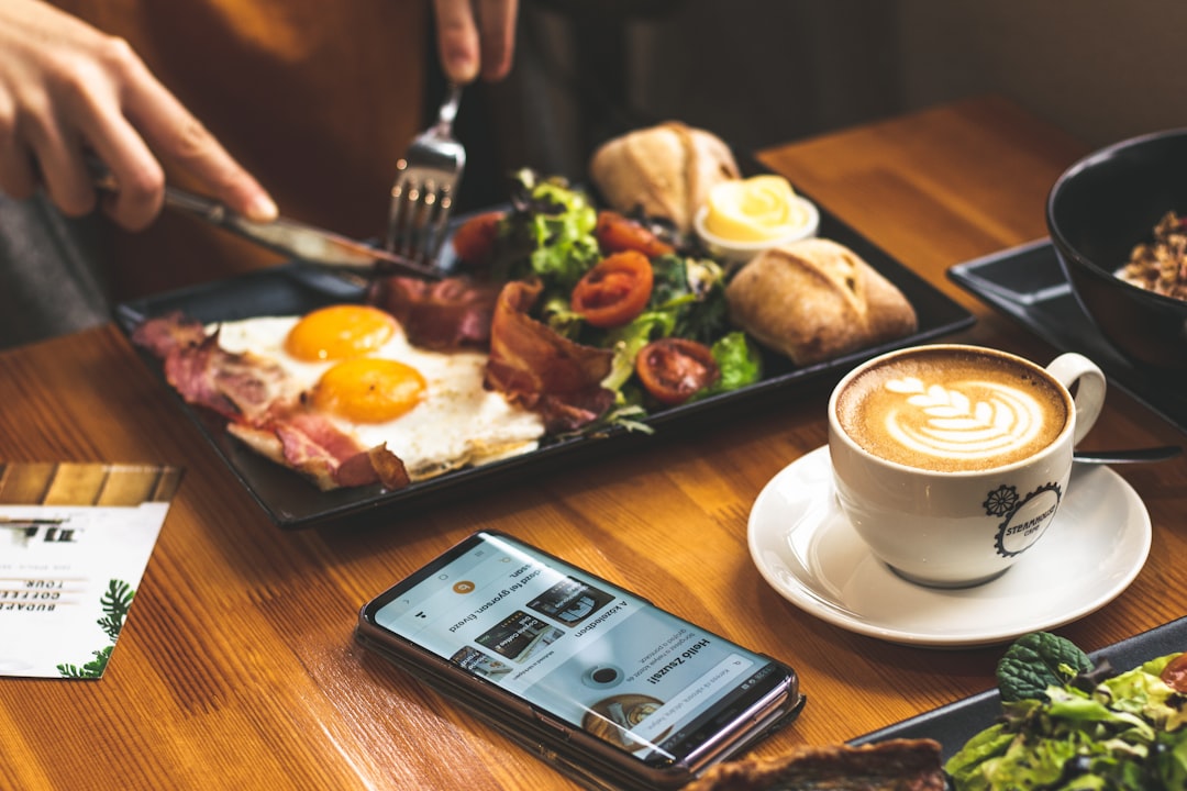 man sitting in front of table with breakfast served mcdonalds mobile app interface, user ordering food, morning setting