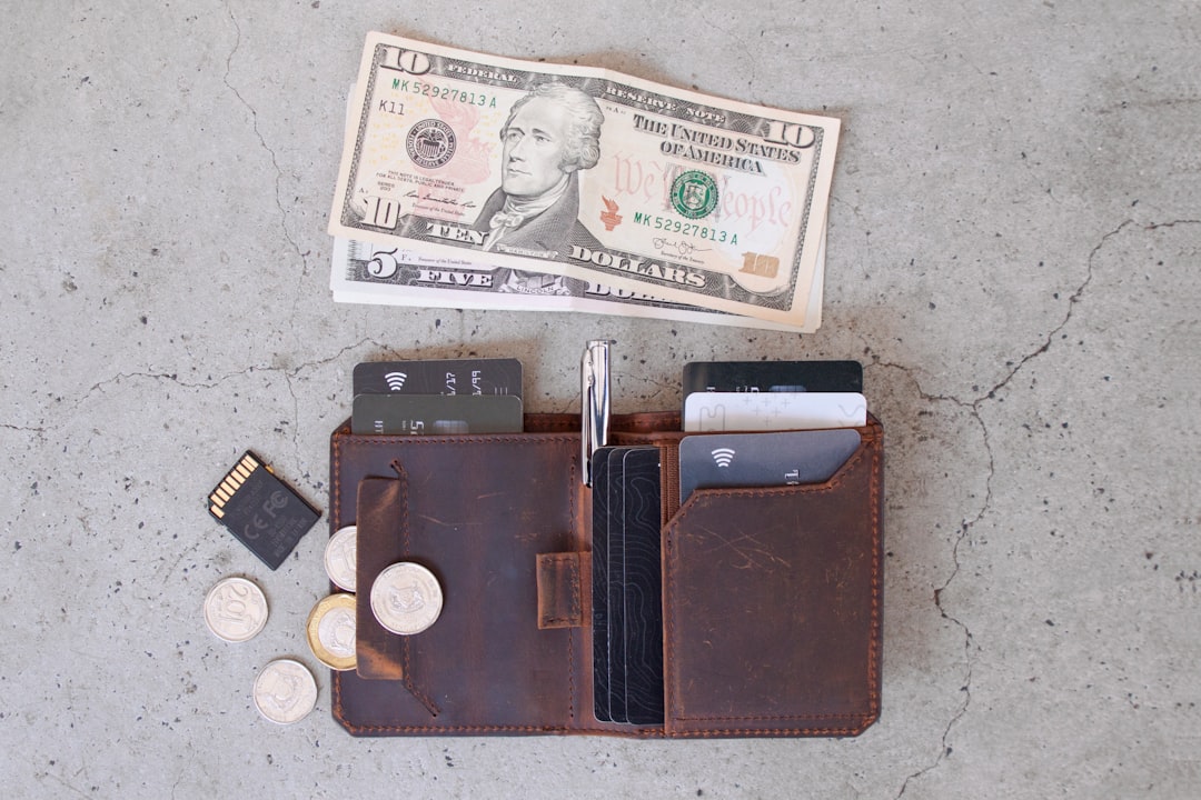 10 us dollar bill beside black leather wallet and coins crypto wallet types, hot wallet, cold wallet