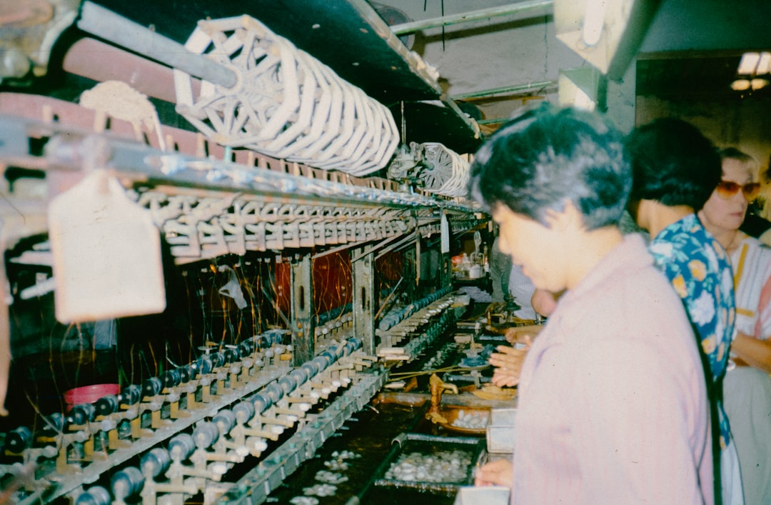 A group of people standing in front of a machine electronics factory, production line, technicians