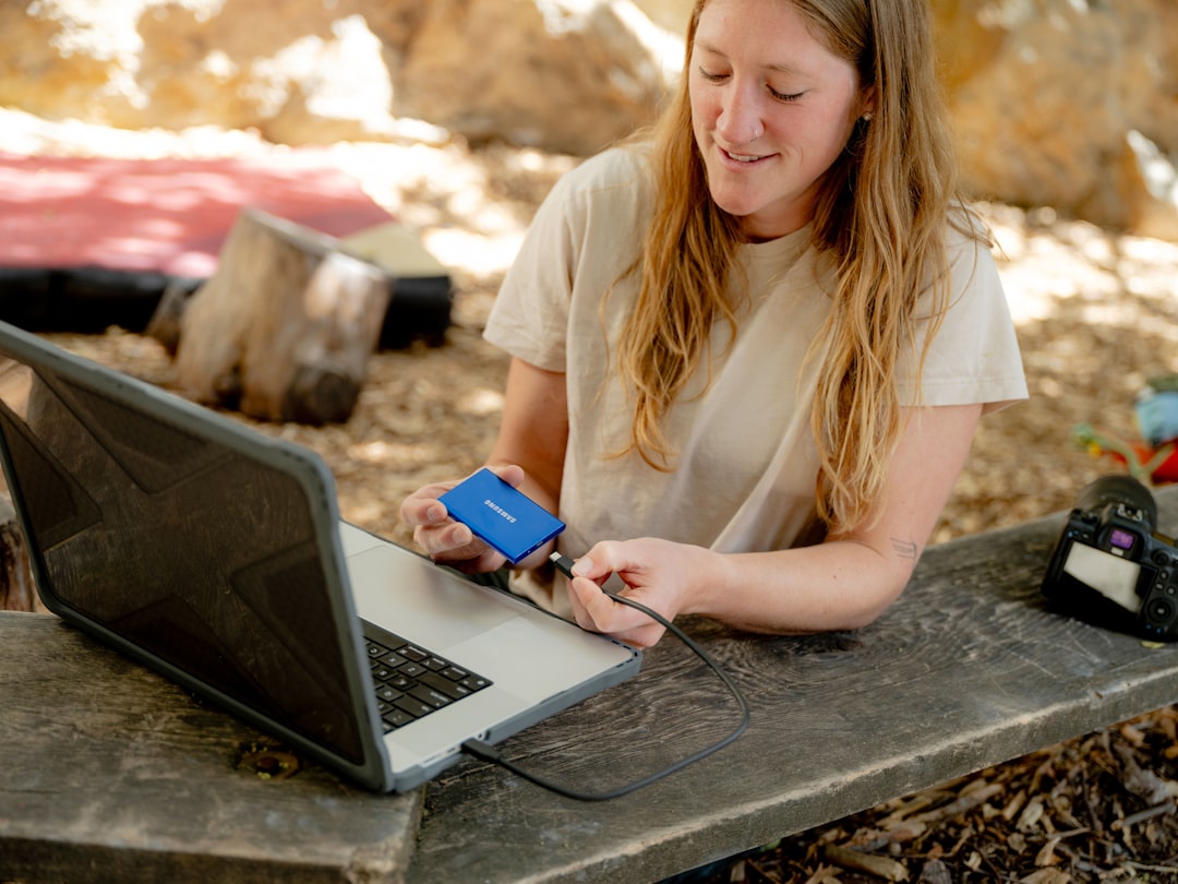 A woman sitting at a table with a laptop and a cell phone mobile learning, remote training, workforce education