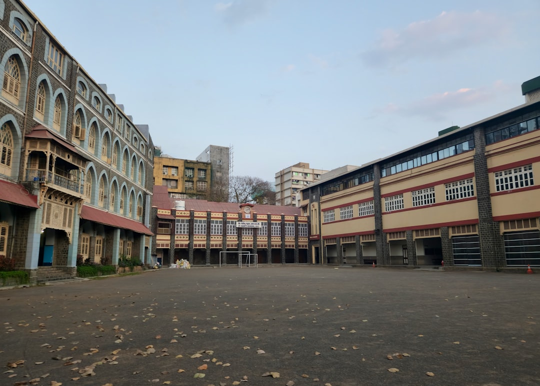 an empty parking lot in front of a row of buildings engineering students, nursing class, business school building